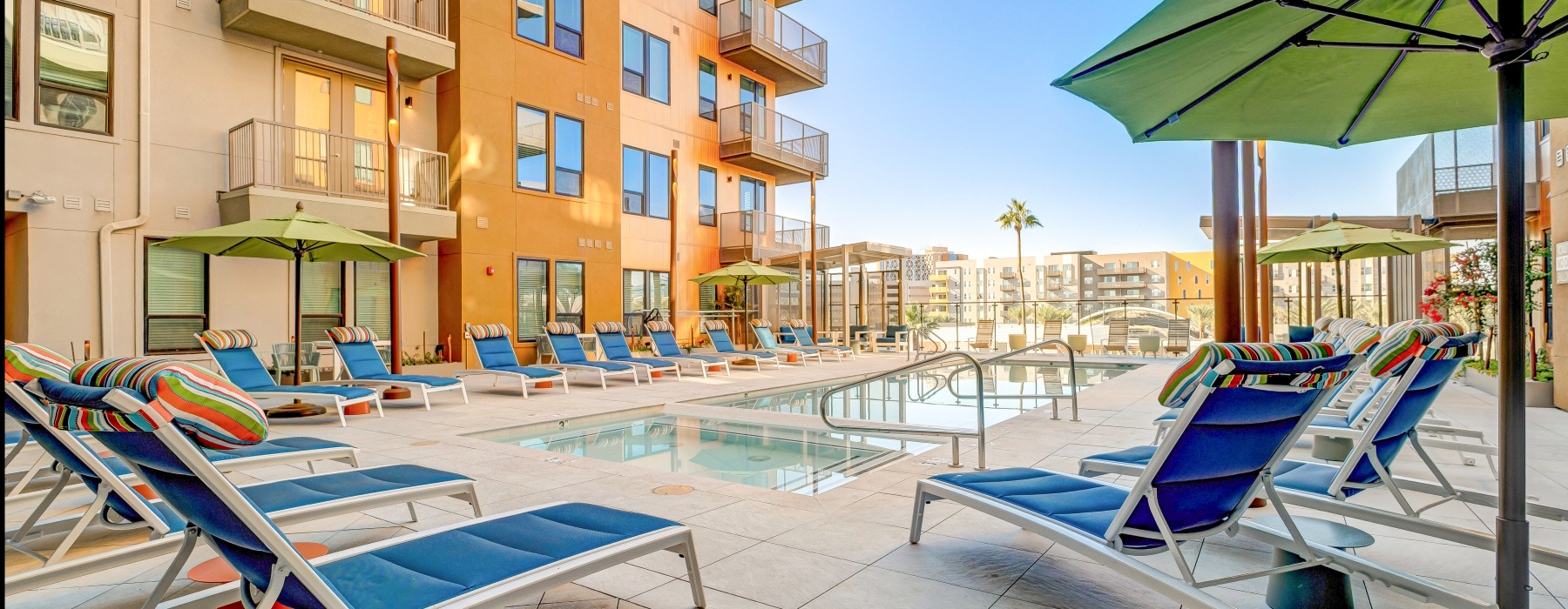 swimming pool with colorful lounge chairs and umbrellas 